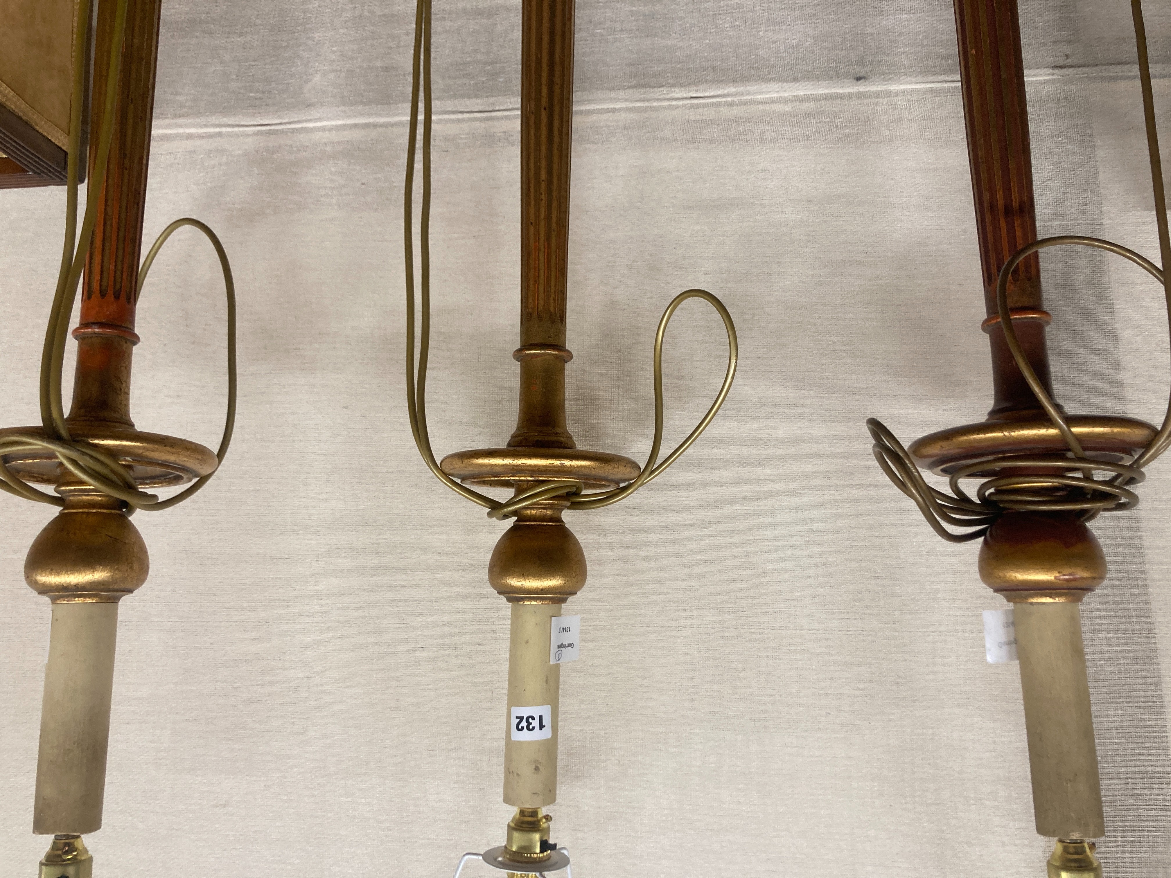 A set of three gilt carved wood lamp standards, height excluding fittings 135cm